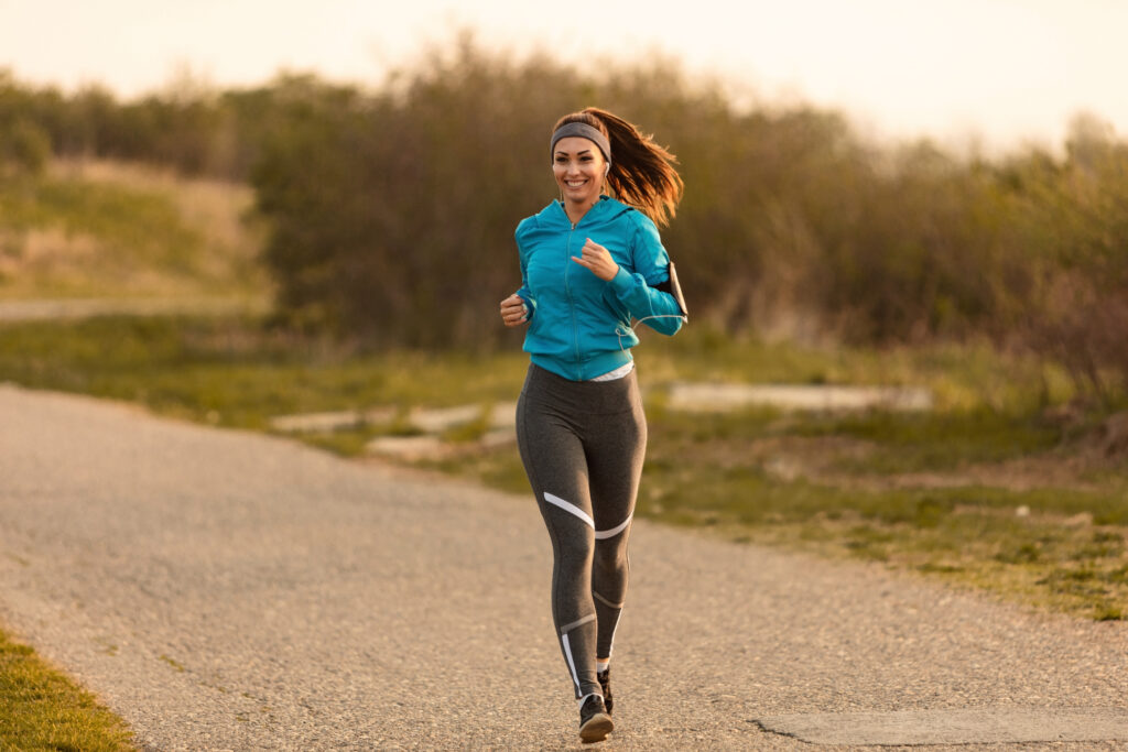 happy female runner jogging on the road.