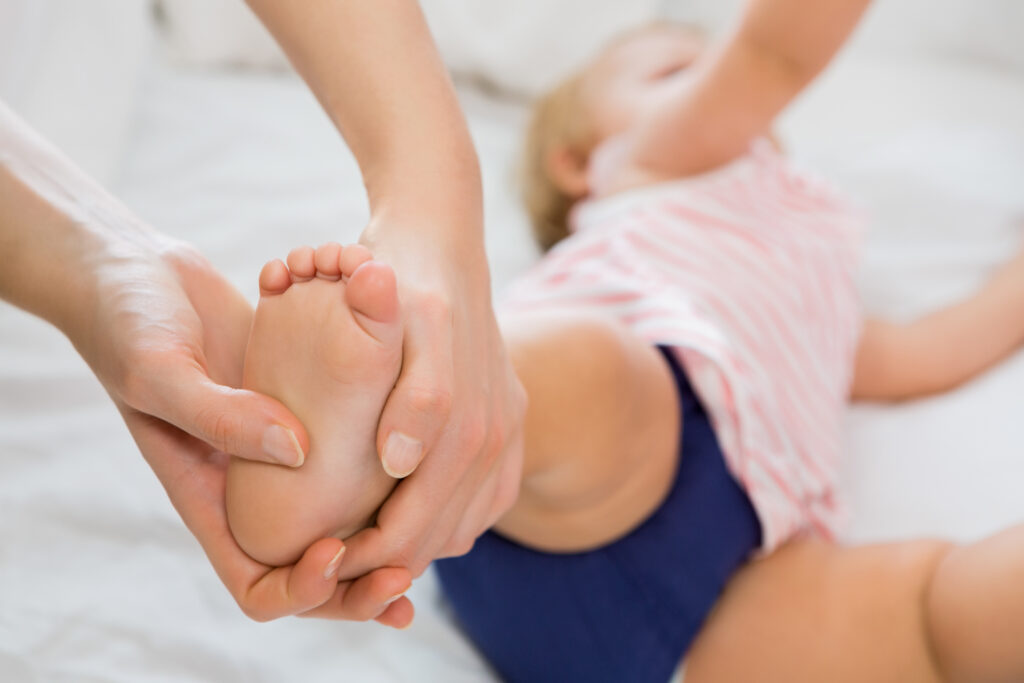 baby girl receiving massage from mother